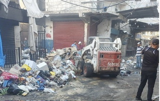 الهيئة الخيرية تزيل النفايات من سوق عين الحلوة